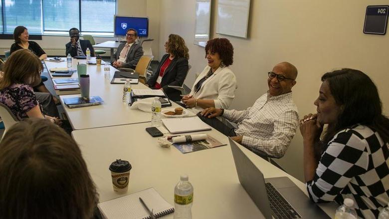 A team from Penn State Harrisburg talks while sitting around a large conference table